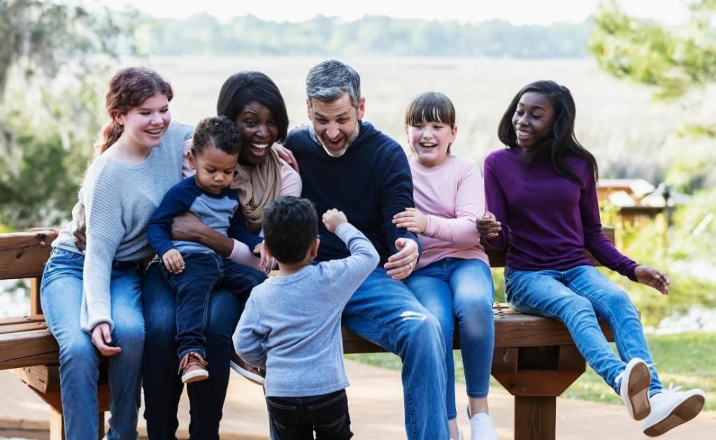 Diverse multi-generational family laughing together outdoors